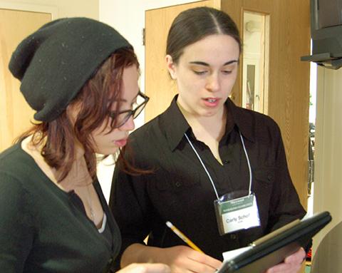 Music education majors Nadia Lipperini and Carly Scholla plan the day's events outside the Latour Room at the Senior Wind Band Celebration. Photo credit Katlynn Whitaker