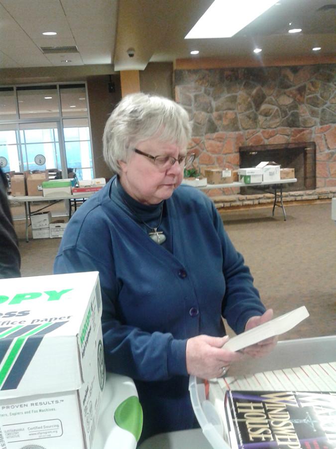 Dr. Bush cleans up books at the conclusion of her final Book Swap on March 26 in the Fireplace Lounge.
