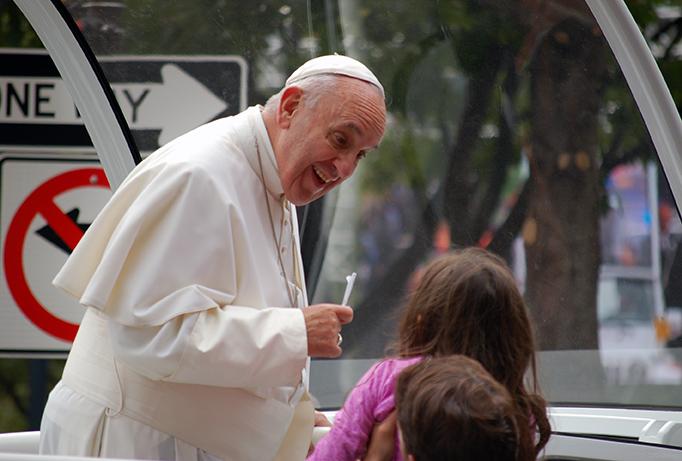 Pope Francis greets a young girl on his way down the Benjamin Franklin Parkway before the Papal Mass in Philadelphia. 