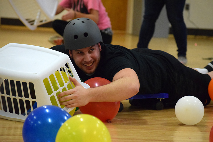 Student Nick Marilou traps balloons for his team during the Human Hungry Hungry Hippos event. 