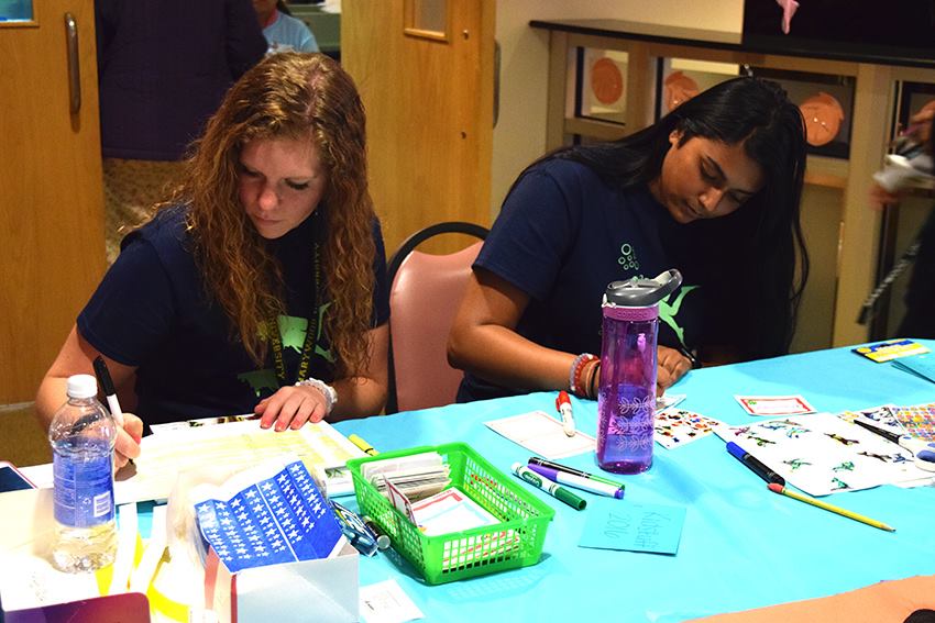 Kidstuff student volunteers Claudia Shandra and Deanna Ramdeo work outside of the Latour Room.