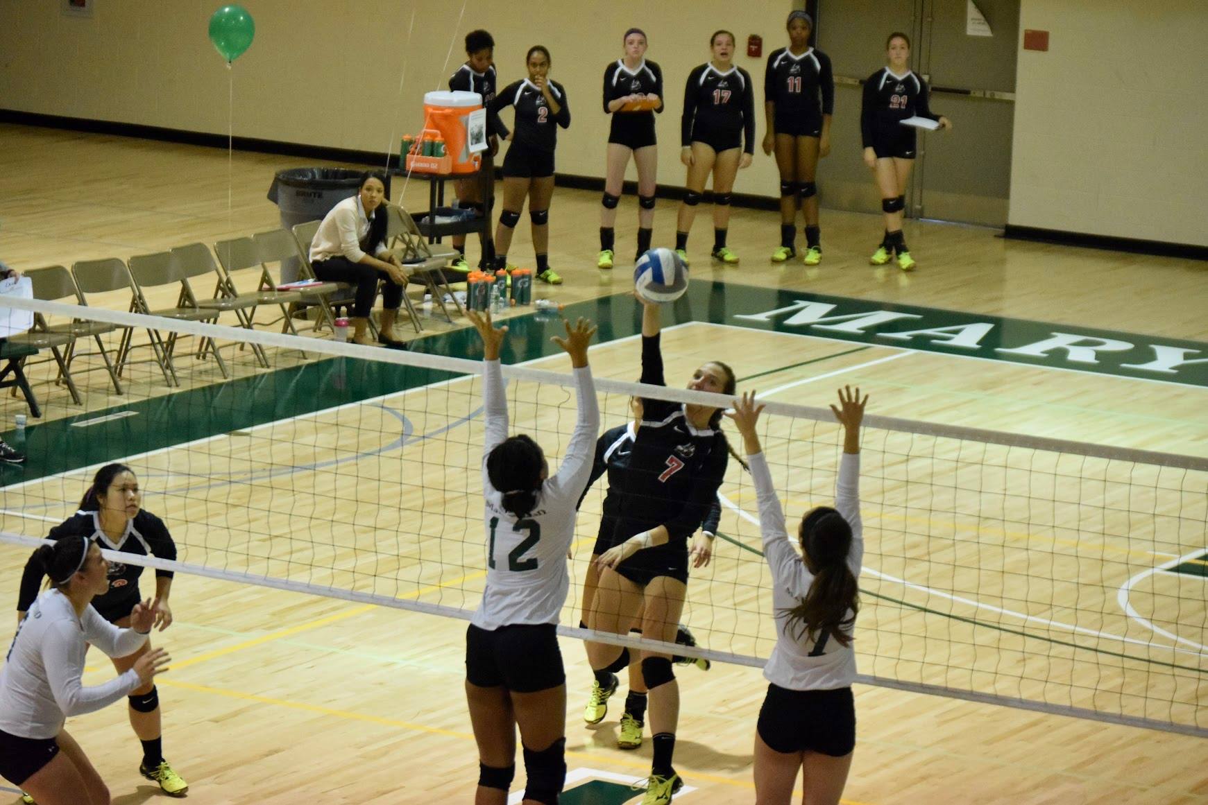 Freshman Mikayla Attwood and junior Danielle DeIulio attempt to block a spike from the Valiant's Kerry Mackey