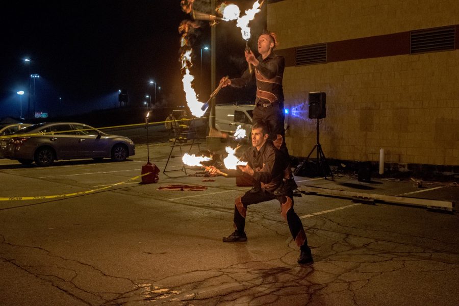 Tim Ellis juggles fire batons while balancing fellow performer Michael Mucciolo on his legs.