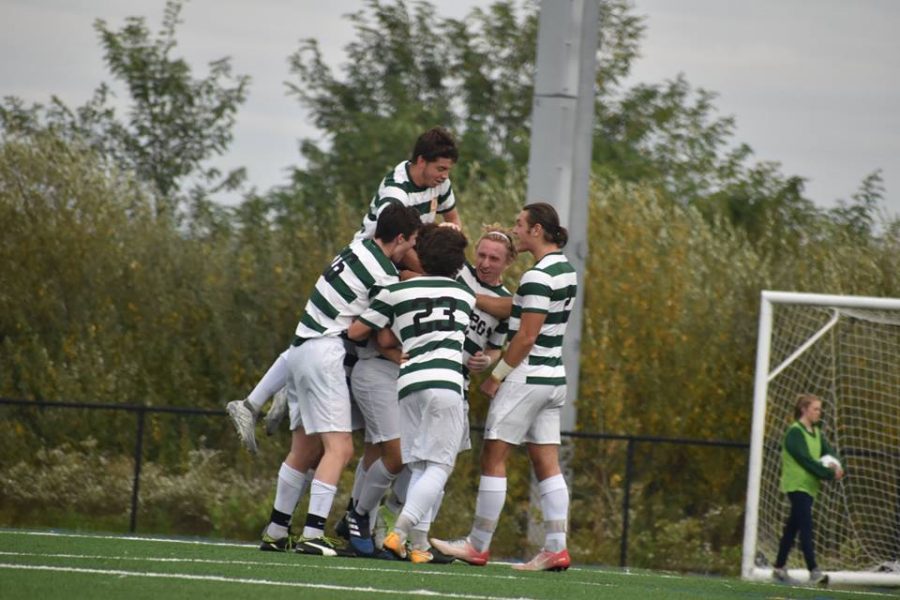 The men's soccer team celebrates after scoring a goal against the Highlanders.