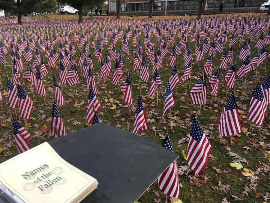 Flags fly next to a binder with the names of those who served. 