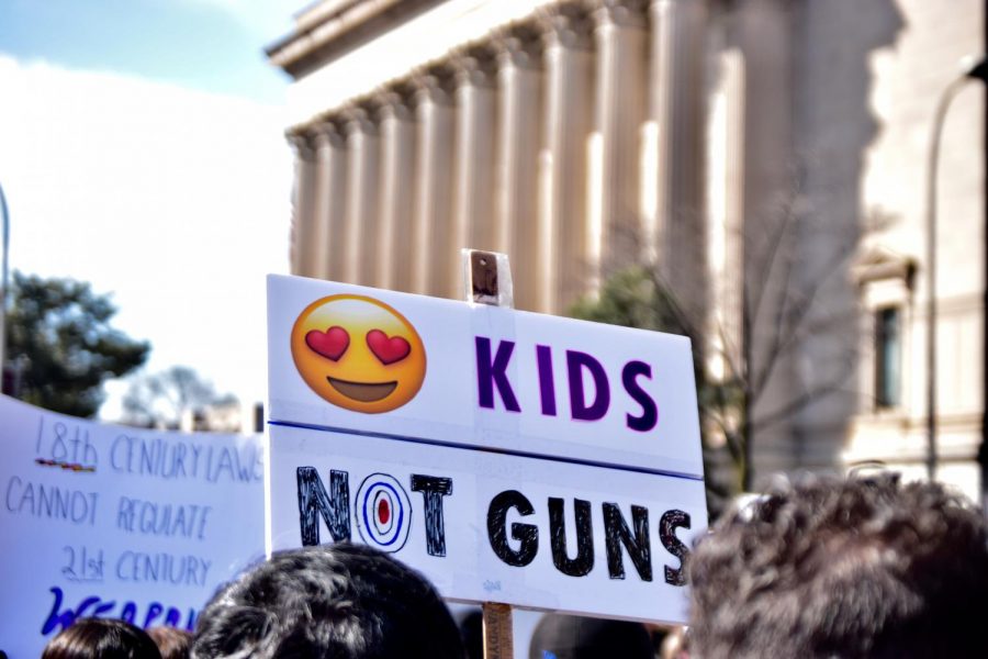 Attendees at the March for Our Lives rally hold signs.