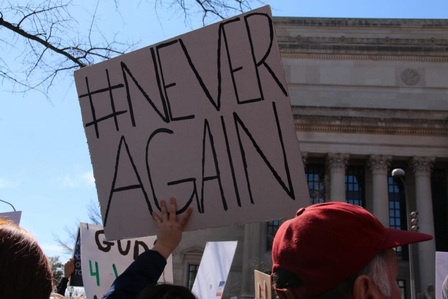 Attendees at the March for Our Lives rally hold signs.
