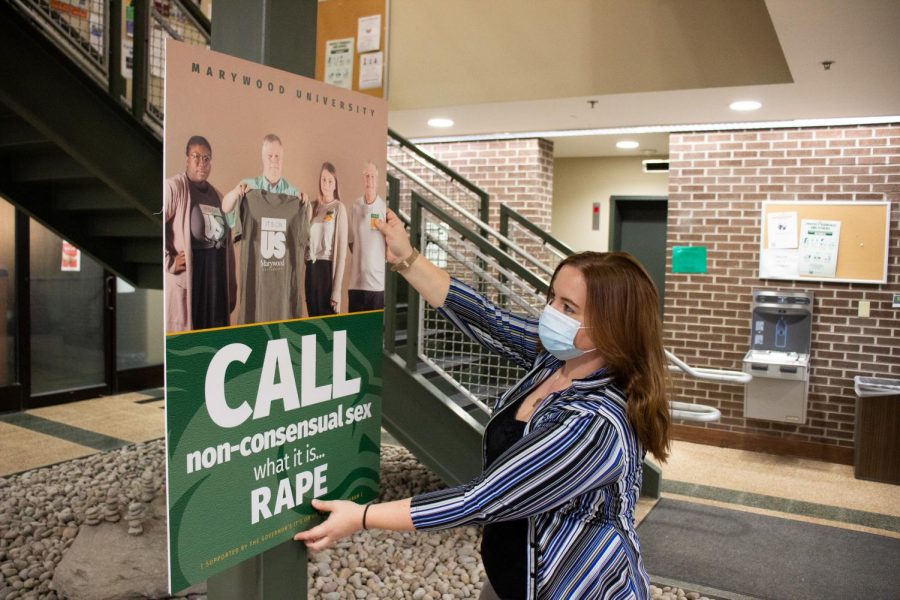 Student therapist for the counseling center, Dalice Hess, displays posters for Marywood University's "It's On Us" week.