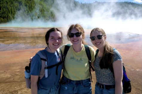 Sara Paulson (left), Molly Butler (middle), and Alana Simrell (right) stand in front of Old Faithful at Yellowstone National Park. The three friends traveled across the country in May to take in the sights.