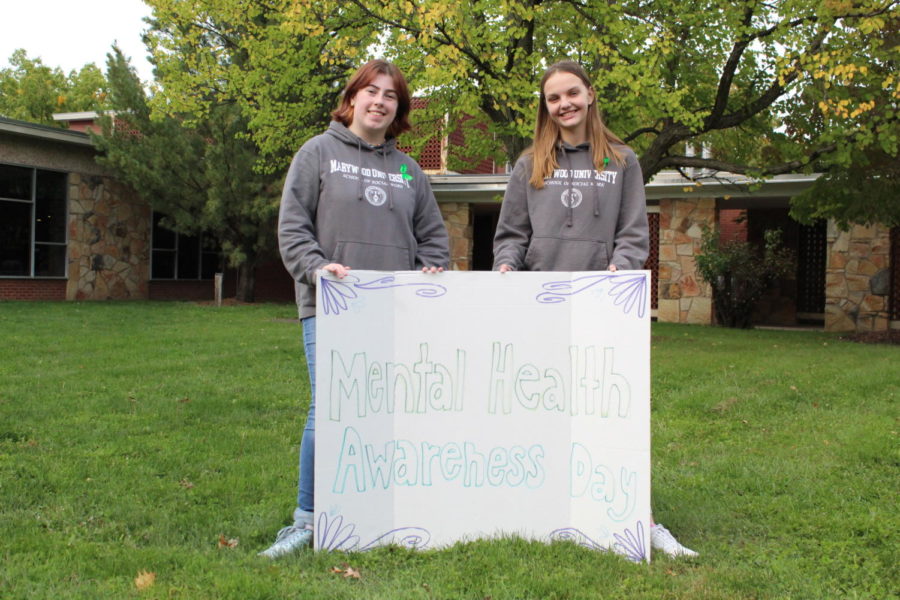 Student+organizers%2C+Katie+Csisack+%28left%29+and+Alyssa+Tkacz+%28right%29+hold+Mental+Health+Awareness+Day+sign.